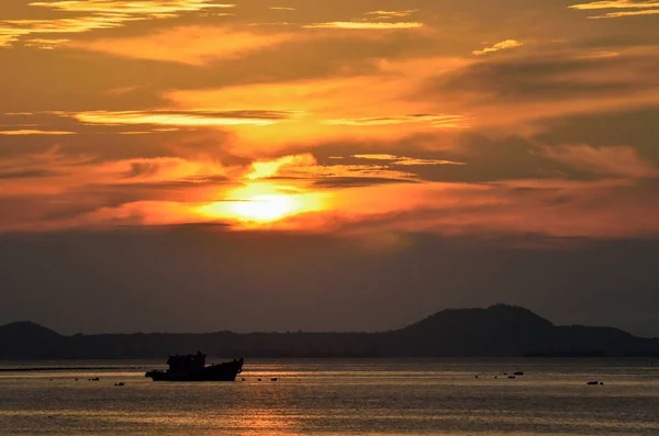 Günbatımının arka planında, denize demirleyen teknenin silueti. — Stok fotoğraf