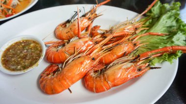 Beyaz tabakta ızgara karidesler, deniz ürünleri mangalı.