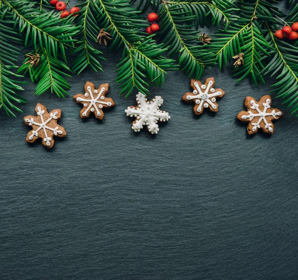 框架与杉木树枝, 饼干和圣诞节装饰在深色木背景。顶部视图. — 图库照片