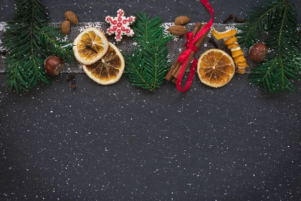 モミの枝、クッキー、暗い石の背景のクリスマスの装飾のあるフレーム。トップ ビュー. — ストック写真