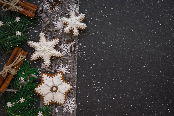 Cornice con rami di abete, biscotti e decorazioni natalizie su sfondo in pietra scura. Vista dall'alto . — Foto Stock