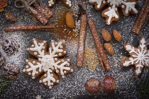 Fondo de Navidad o Año Nuevo de galletas de jengibre, especias, nueces con azúcar y copos de nieve. Vista superior . —  Fotos de Stock