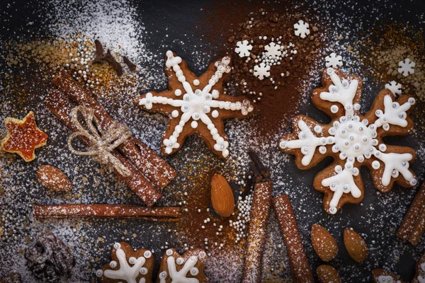 Natal ou Ano Novo fundo de biscoitos de gengibre, especiarias, nozes com açúcar e flocos de neve. Vista superior . — Fotografia de Stock