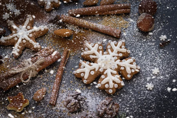 Fondo de Navidad o Año Nuevo de galletas de jengibre, especias, nueces con azúcar y copos de nieve. Vista superior . — Foto de Stock