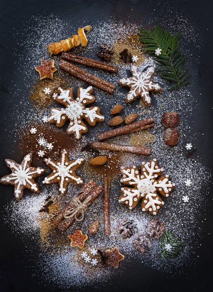 Boże Narodzenie czy nowy rok tło pierniki, przyprawy, orzechy z cukrem i płatki śniegu. Widok z góry. — Zdjęcie stockowe