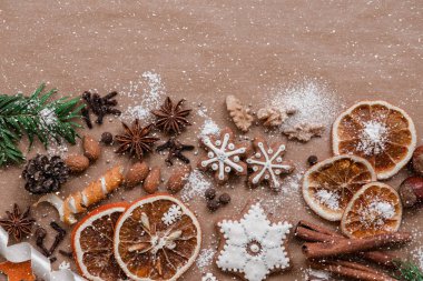 Çerçeve çam dalları, kurabiye ve koyu kahverengi kağıt arka plan üzerinde Noel süslemeleri ile. Üstten görünüm.