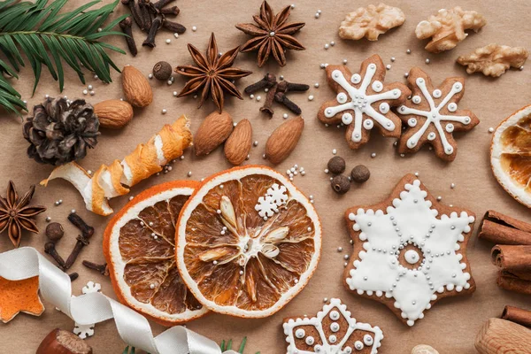 Frame with fir branches, cookies and Christmas decorations on dark brown paper background. Top view. — Stock Photo, Image