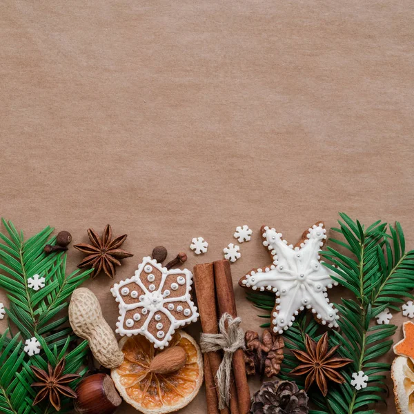 Decoro natalizio con spezie e biscotti a forma di fiocchi di neve su sfondo di carta marrone scuro. Vista dall'alto . — Foto Stock