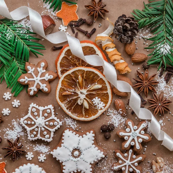 Decoro natalizio con spezie e biscotti a forma di fiocchi di neve su sfondo di carta marrone scuro. Vista dall'alto . — Foto Stock