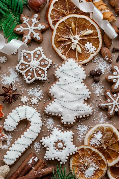 Karácsonyi dekoráció fűszerek és a cookie-kat, az alakja a háttér sötét barna papír hópelyhek. Szemközti nézet. — Stock Fotó