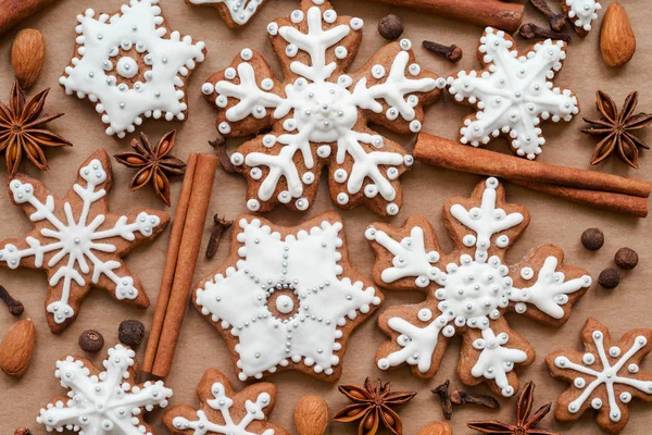 Christmas dekoration with spices and cookies in the shape of snowflakes on dark brown paper background. Top view. — Stock Photo, Image