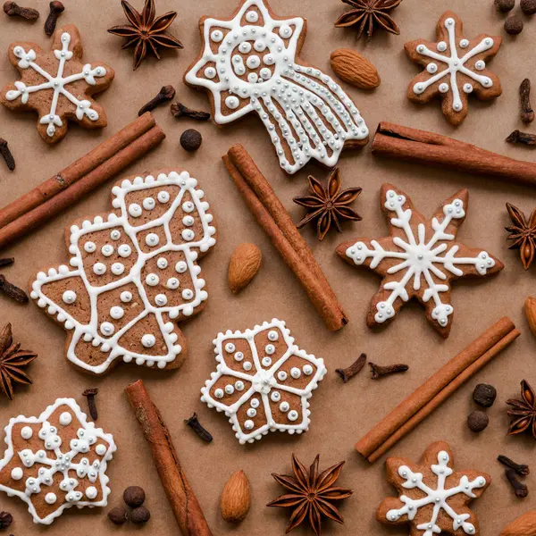 Decoro natalizio con spezie e biscotti a forma di fiocchi di neve su sfondo di carta marrone scuro. Vista dall'alto . — Foto Stock