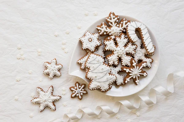 Dekorasi Natal dengan kue dalam bentuk kepingan salju dan bintang-bintang di latar belakang putih — Stok Foto