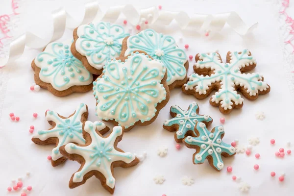 Decoración navideña con galletas en forma de copos de nieve y estrellas sobre fondo blanco — Foto de Stock