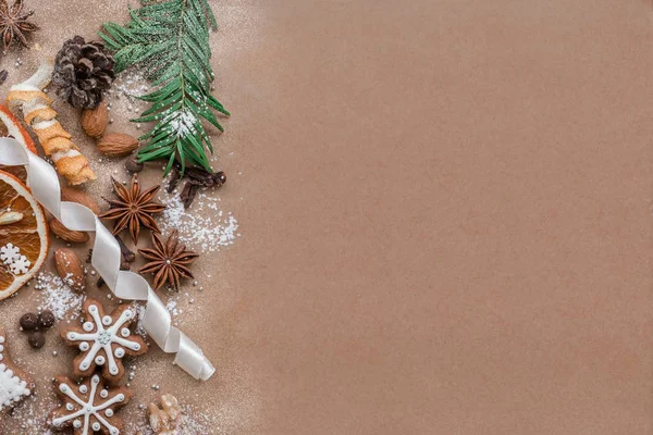 Decoração de Natal com especiarias e biscoitos em forma de flocos de neve sobre fundo de papel marrom escuro. Vista superior . — Fotografia de Stock