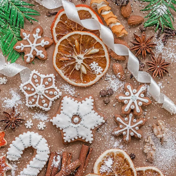 Decoración navideña con especias y galletas en forma de copos de nieve sobre fondo de papel marrón oscuro. Vista superior . —  Fotos de Stock