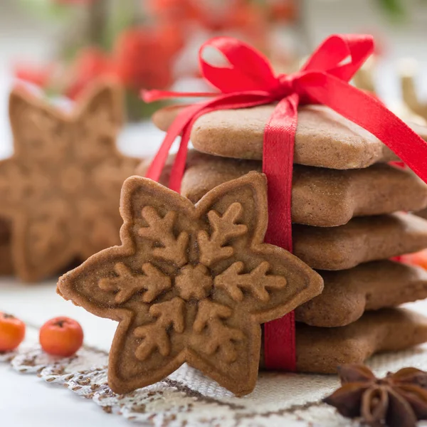 Biscoitos de Natal feitos à mão em forma de estrelas com fita vermelha — Fotografia de Stock