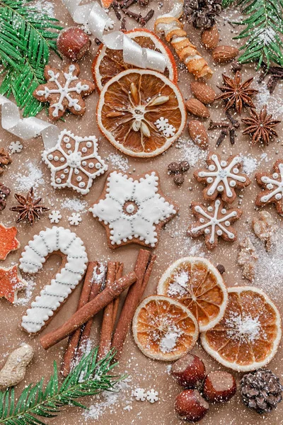 Vánoční dekorace s kořením a cukroví ve tvaru sněhové vločky na tmavě hnědém papírovém pozadí. Pohled shora. — Stock fotografie