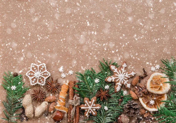 Décoration de Noël avec des épices et des biscuits en forme de flocons de neige sur fond de papier brun foncé. Vue du dessus . — Photo