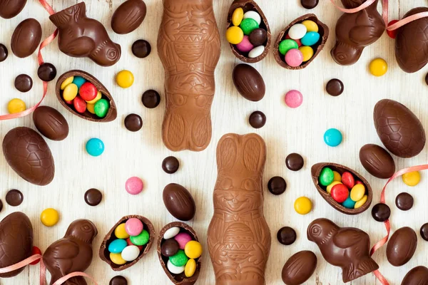 Paskalya arka plan ile tavşan, tavuk, yumurta ve tatlılar şeklinde çikolata şekerleme — Stok fotoğraf