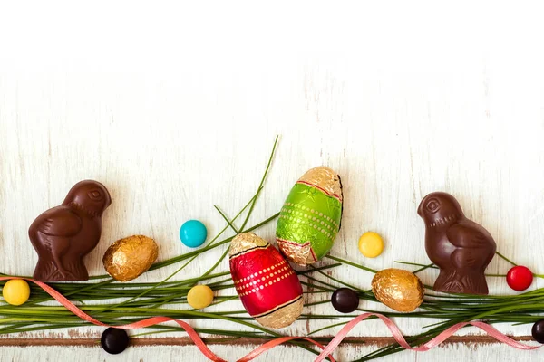 Fond de Pâques avec des bonbons au chocolat en forme de lapin, poulet, oeufs et bonbons — Photo