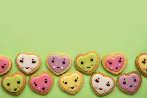 Heart shaped sugar cookies decorated with pastel royal icing on pink background. Fairy tales concept. Top view.