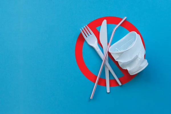 公害の象徴として青色の背景に白色のプラスチック単一の食器 禁止使い捨てプラスチック — ストック写真