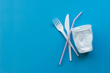 Mavi bir arka plan üzerinde beyaz tek kullanımlık plastik ve plastik içecek payet. Tek Kişilik Kullanım plastik için Hayır