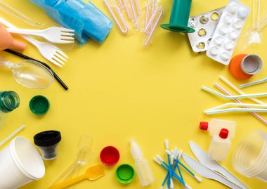 Beyaz tek kullanımlık plastik ve diğer plastik parça üstünde sarı bir arka plan