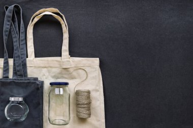 Pamuk alışveriş çantası, kavanoz, şişe ve koyu mavi arka plan iş parçacığında pişirme