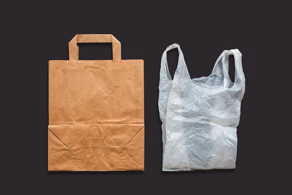 Papírové a plastové tašky na tmavém pozadí. — Stock fotografie