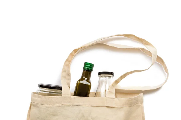Bavlněná nákupní taška s sklenici a láhev na bílém pozadí — Stock fotografie