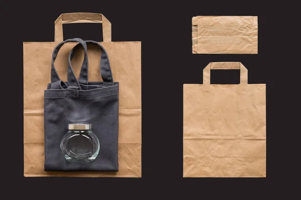 Shopping bag in cotone, sacchetto di carta e vaso isolato sullo sfondo nero — Foto Stock