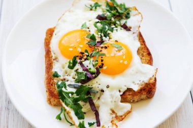 Sahanda yumurta beyaz bulaşık görünümün üst kıyılmış yeşillikleri ile ekmek üzerinde iki sarısı ile