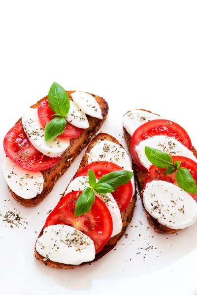 Tostadas con queso mozzarella y tomates frescos con albahaca joven —  Fotos de Stock