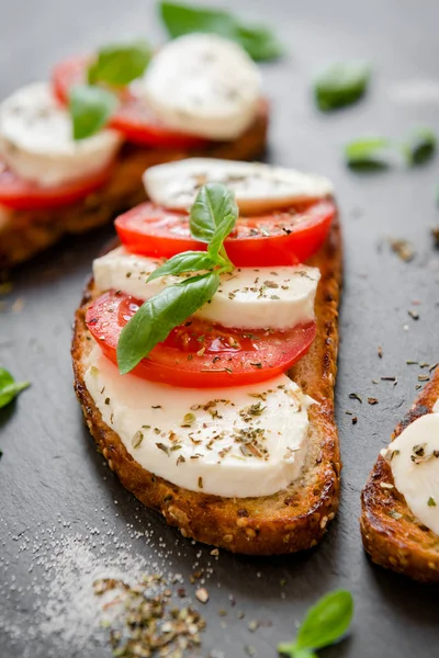 Tostadas con queso mozzarella y tomates frescos con albahaca joven —  Fotos de Stock