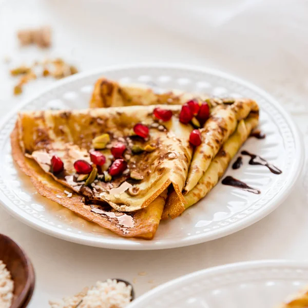 Thin Crepes with melted chocolate, sesame seeds, pomegranate and almonds — Stock Photo, Image