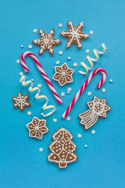 Gingerbread cookies and candy canes on a blue background — Stock Photo, Image