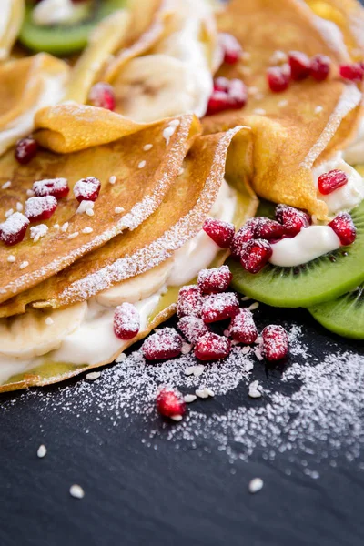 Thin Crepes with melted chocolate, sesame seeds, pomegranate and almonds — Stock Photo, Image