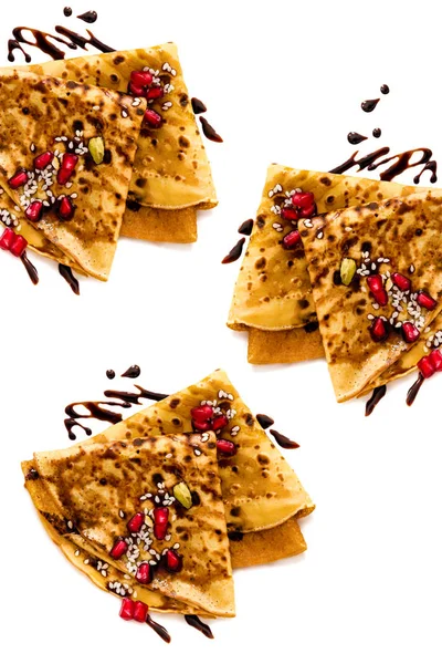 Thin Crepes with melted chocolate, sesame seeds, pomegranate and almonds — Stock Photo, Image