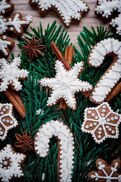 Cornice con rami di abete, biscotti e decorazioni natalizie su sfondo di carta marrone scuro. Vista dall'alto . — Foto Stock