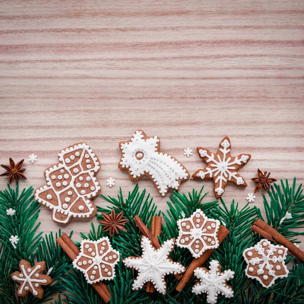 Ahşap arka planda köknar dalları, kurabiyeler ve Noel süslemeleri olan çerçeve. Üst görünüm. — Stok fotoğraf