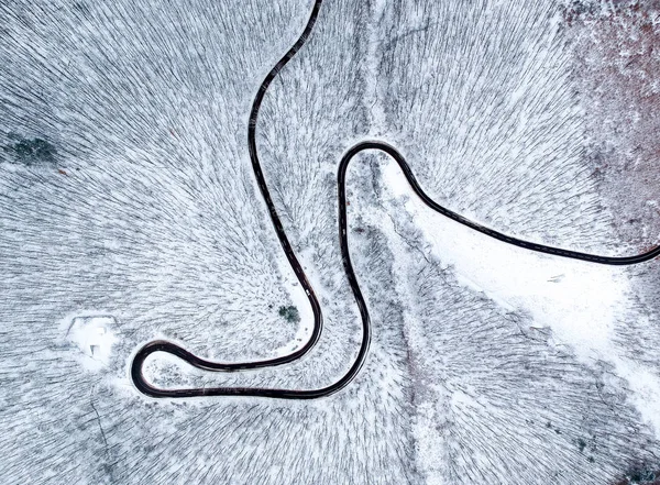 Вид з повітря на звивисту дорогу взимку — стокове фото