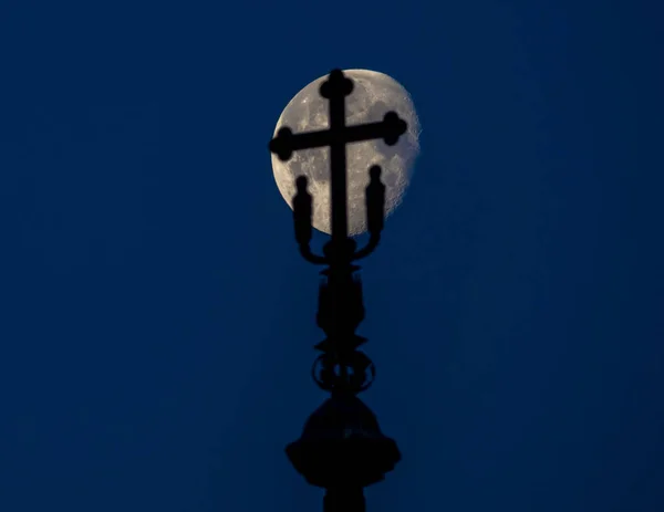 Silhouette on the top of a church with the moon in the background — Stock Photo, Image