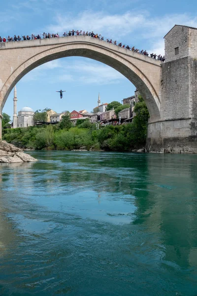 MOSTAR, BOSNIA- APRIL 21: Man jumping from old bridge on APRIL 21, 2019 in Mostar, Bosnia. Ini adalah tradisi bagi pria untuk menyelam dari jembatan 21m — Stok Foto