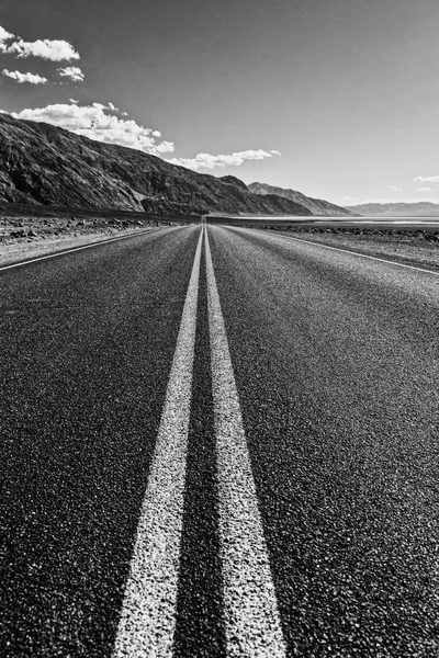 Vista de uma estrada reta sem fim que atravessa o deserto — Fotografia de Stock