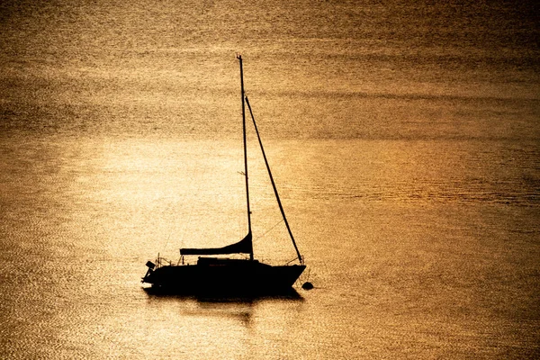 Silhuett av en segelbåt som flyter på en sjö — Stockfoto