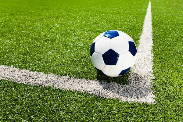 Soccer football ball on the corner line on the stadium field