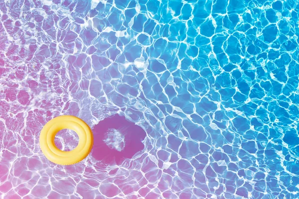 用复制空间浮在蓝水面上的空黄色橡胶圈的高角度观 — 图库照片