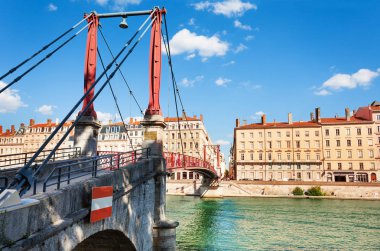Saint Georges footbridge with beautiful ancient buildings on the Saone river embankment in background, Lyon, France clipart